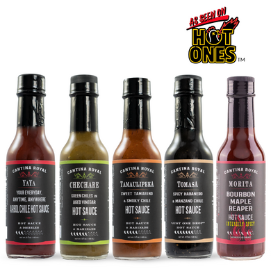 A selection of five hot sauces in glass bottles with labels, from the Heat Seekers Deluxe Gift Box.